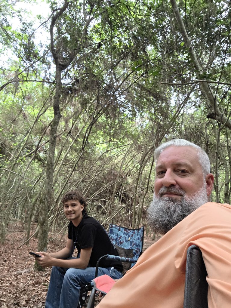 Heath Ledet relaxing in a wooded area with another person.