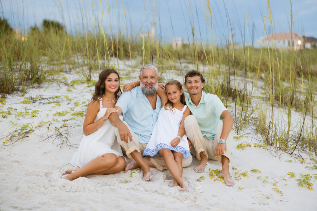 Heath Ledet posing with family on a sandy beach