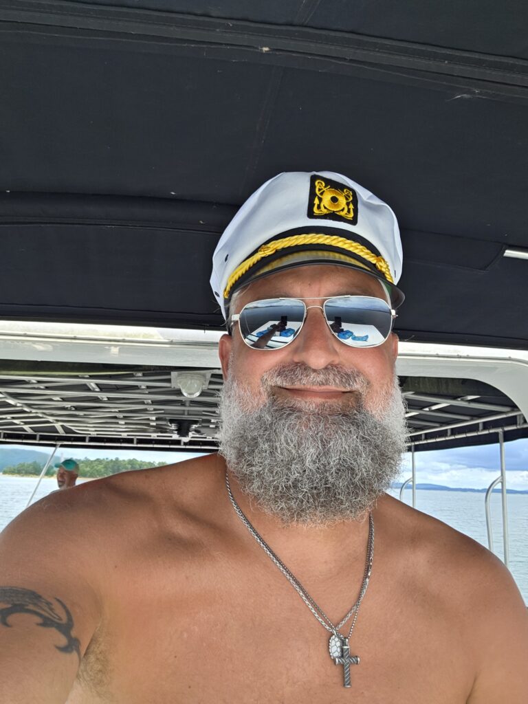 Heath Ledet wearing a captain hat and sunglasses on a boat